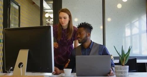 Front view of young cool mixed-race business team planning and working at desk in a modern office 4k