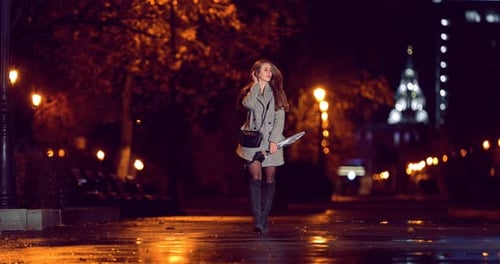 Pretty Girl Walks Along the Alley with an Umbrella
