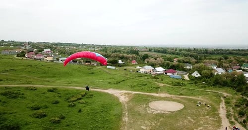 Paraglider Prepares for Flight on Grassy Field