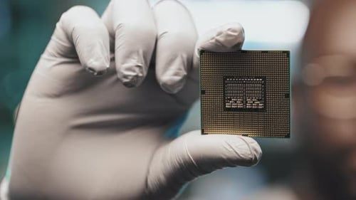 Lab Engineer in Gloves Holding Microprocessor