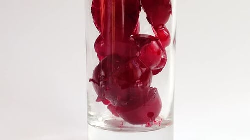 Glass being filled with red cherry juice