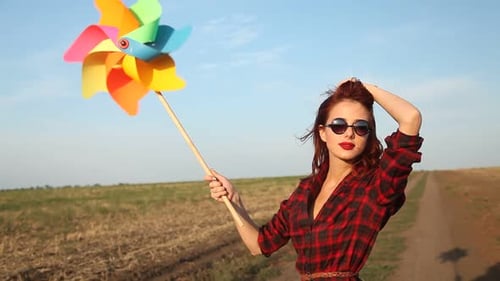 Woman Holding Pinwheel on a Rural Path