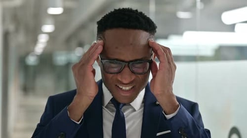 Stressed Man Massaging Temples in Office