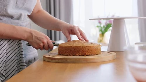 Woman Cutting Baked Cake with Knife at Home