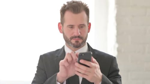 Smiling Businessman Using Phone