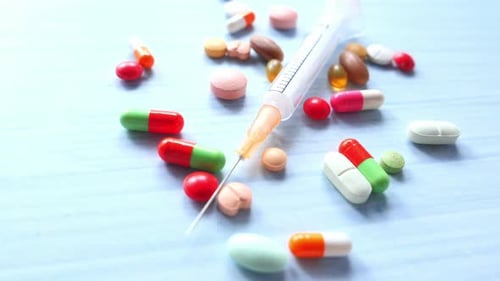 Syringe and Pills on White Background, Close Up