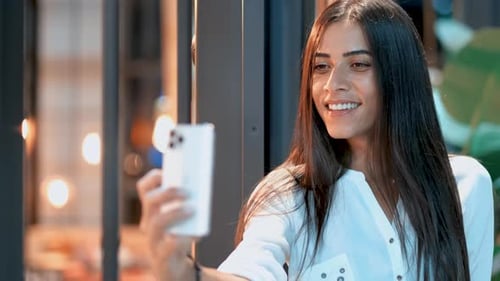 Smiling Woman Taking Selfie with Phone Indoors