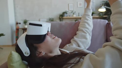 Woman Experiencing Virtual Reality Laying on Couch
