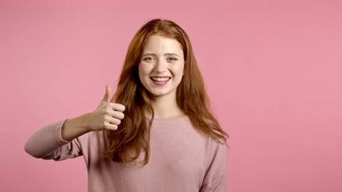 Happy Woman Gives Thumbs Up on Pink Background