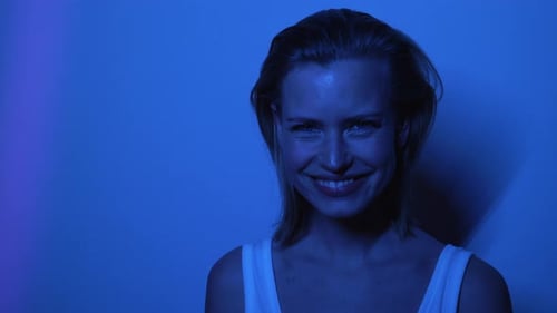 Smiling Woman with Blonde Hair in Blue Light
