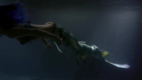 Magische schlanke und schöne weibliche Meerjungfrau schwimmt in der Tiefe des Ozeans und winkt mit ihrem langen Schwanz
