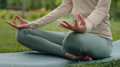 Woman hands close up practices yoga and meditates in lotus position.