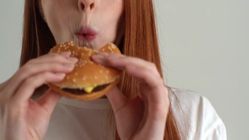 Young Woman Enjoying a Burger Close Up