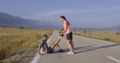 Couple of Determined Athletes Stretching Together Warming Up and Preparing for Running Training on a