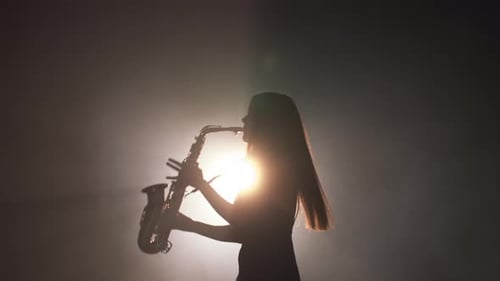 Silhouette of Woman Playing Saxophone in Smoky Atmosphere