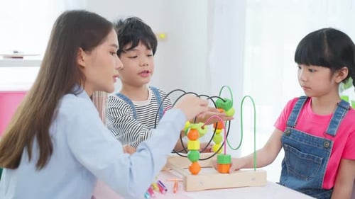 Children Playing with Bead Maze Toy with Teacher