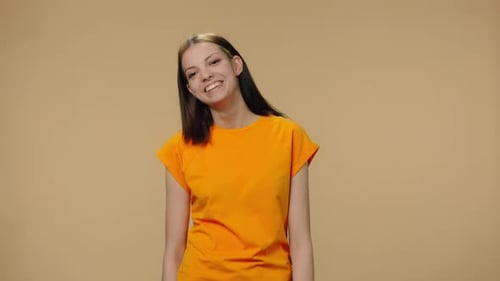 Smiling Young Woman in Orange T-shirt Posing
