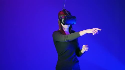 Woman Using VR Headset in Blue Lit Studio