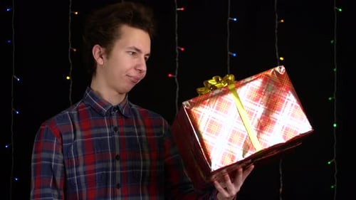 Young Adult Holds Holiday Gift in Studio