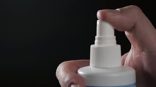 Closeup View of Human Hand and Spray Bottle Isolated on Black Parfume