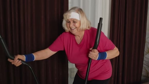 Senior Woman Exercising on Elliptical Machine at Home