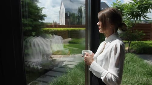 Woman Drinking Coffee Enjoying View From Window