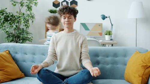 Calm Woman Meditating at Home with Child