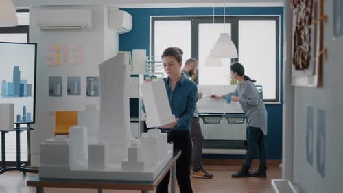 Portrait of Employee Working with Building Model and Maquette to Design Blueprint Plan