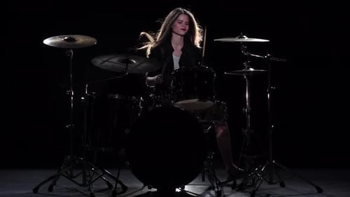 Young Woman Plays Drums in Dark Studio