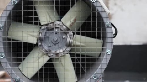 Industrial Fan with Spinning Blades in Metal Frame