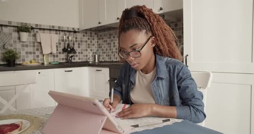 Woman Studying with Tablet in Bright Kitchen