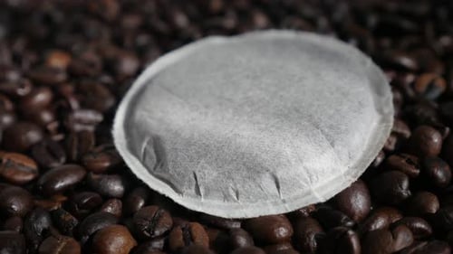 Coffee Pod on Pile of Roasted Coffee Beans