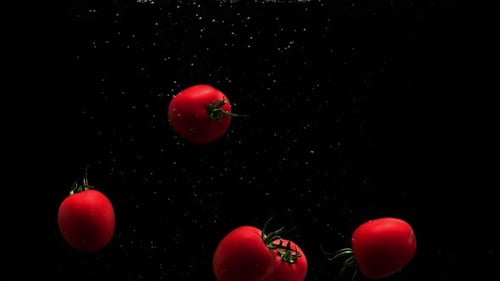 Cherry Tomatoes Falling into Water in Slow Motion