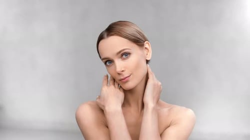 Naked Female Model with Perfect Skin and Natural Makeup Posing at White Studio Background