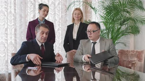 Businessmen Signing Documents, Handshake at Meeting