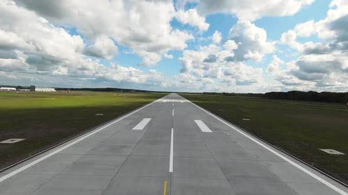 Empty Asphalt Runway with White Marking in Green Field