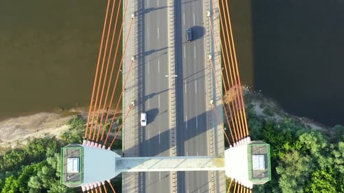 Caring on modern cable stayed bridge over sea in developed city aerial view