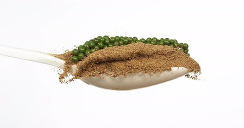 Fresh green pepper, piper nigrum, spice falling in pepper ground on white background, slow motion 4K