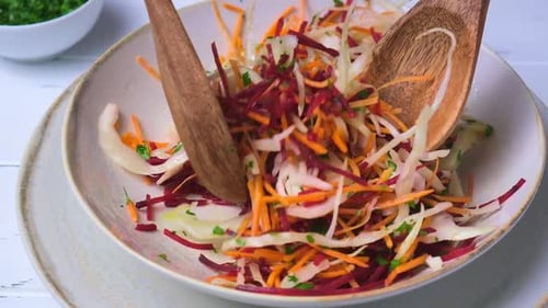 Rote Beete, Karotte, Kohlsalat mit Öl und Kräutern, grauer Hintergrund.