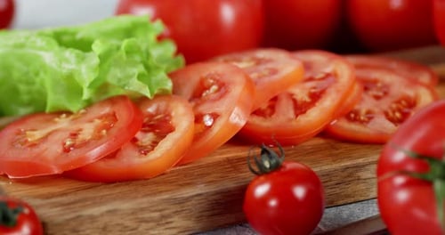 Sliced Red Tomatoes and Lettuce on Cutting Board