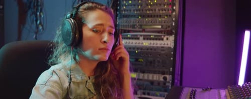 Woman Working with Mixing Desk in Recording Studio