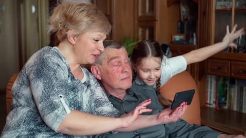 Family Time: Grandparents with Child Using Phone