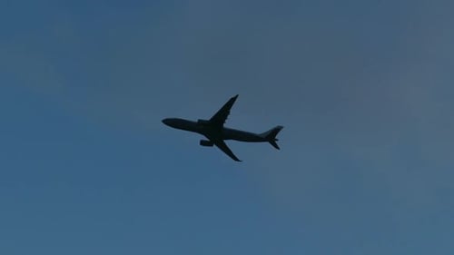 Airplane flying in the cloudy blue sky