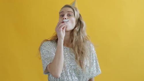 Woman with Party Hat Blows Party Horn