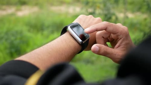 Man Interacting with Smart Watch Outdoors