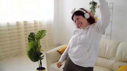 Woman Dancing Energetically with Headphones at Home