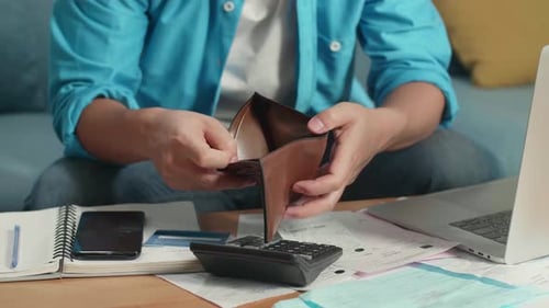Nahaufnahme der Hand eines Mannes, der die Brieftasche hält und öffnet, um Geld zu überprüfen