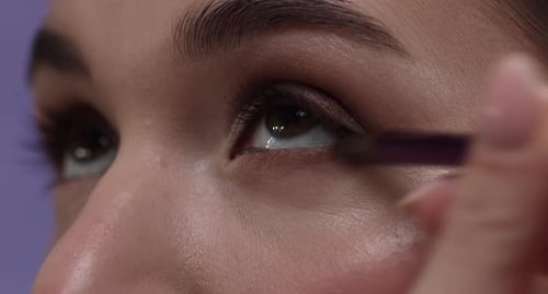 Woman Applying Eyeliner with Brush Close Up