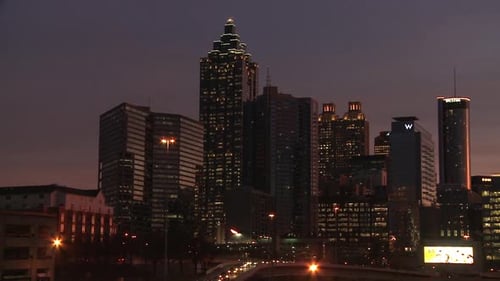 Panning, medium shot from left to right of the Atlanta Skyline at night with illuminating lights.