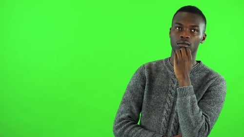 A Young Black Man Thinks About Something and Rubs His Chin - Green Screen Studio